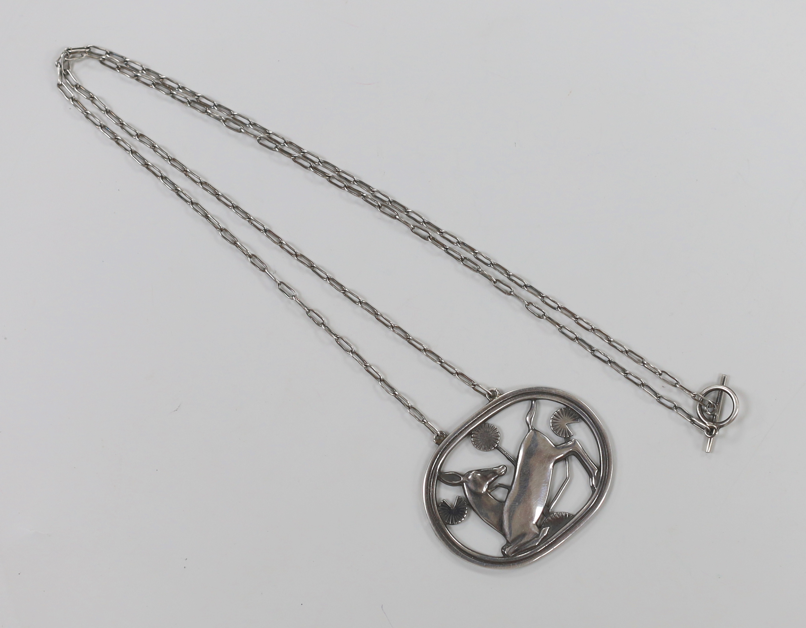 A Georg Jensen sterling oval kneeling deer pendant necklace, design no. 95, overall 64cm.